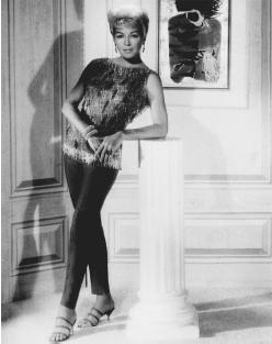 Lana Turner modeling an Edith Head-designed silk pants outfit from the film Love Has Many Faces (1965). Overblouse is covered with crystal beads. © AP/Wide World Photos.